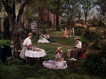 Movie still from “Little Women” (1949), directed by Mervyn LeRoy – A group of people sitting in a yard; Wide shot, High angle