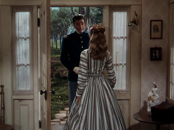 Movie still from “Little Women” (1949), directed by Mervyn LeRoy – A man and a woman standing in front of a door; Medium shot, Over the shoulder angle