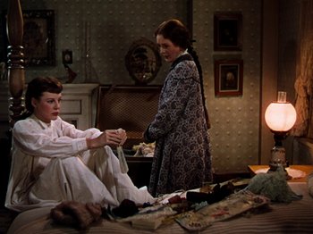 Movie still from “Little Women” (1949), directed by Mervyn LeRoy – Two women are standing in a room and one of the women is holding a pair of socks; Medium shot, High angle