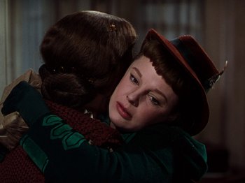 Movie still from “Little Women” (1949), directed by Mervyn LeRoy – A woman hugging another woman in a green dress; Close Up shot, Over the shoulder angle