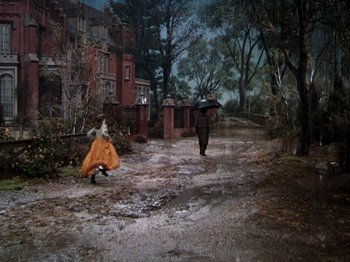 Movie still from “Little Women” (1949), directed by Mervyn LeRoy – Two people walking down a dirt road in the middle of the day; Wide shot, High angle