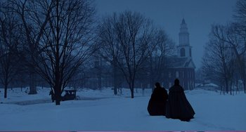 Movie still from “Little Women” (1994), directed by Gillian Armstrong – Two people sitting in the snow in front of a building; Extreme Wide shot, Low angle