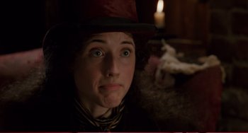 Movie still from “Little Women” (1994), directed by Gillian Armstrong – A young woman wearing a red hat with a candle in the background; Close Up shot, Over the shoulder angle