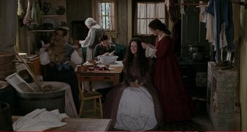 Movie still from “Little Women” (1994), directed by Gillian Armstrong – A group of people sitting around a table with food on it; Wide shot, High angle