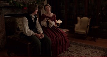 Movie still from “Little Women” (1994), directed by Gillian Armstrong – A man and a woman sitting on a bench in a living room; Medium shot, Over the shoulder angle