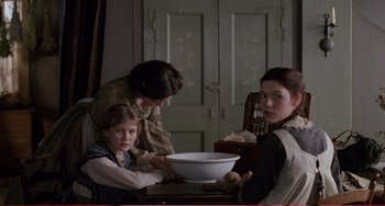 Movie still from “Little Women” (1994), directed by Gillian Armstrong – Three women and a child are in a kitchen; Medium shot, Over the shoulder angle