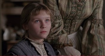 Movie still from “Little Women” (1994), directed by Gillian Armstrong – A young girl wearing a dress and a sweater; Close Up shot, High angle