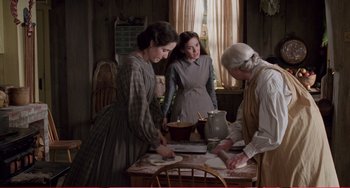Movie still from “Little Women” (1994), directed by Gillian Armstrong – Three women in old - fashioned dress preparing a meal; Medium shot, High angle