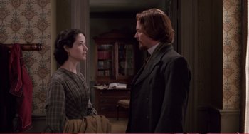 Movie still from “Little Women” (1994), directed by Gillian Armstrong – A man and a woman standing next to each other in a room; Medium shot, Over the shoulder angle