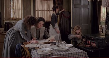 Movie still from “Little Women” (1994), directed by Gillian Armstrong – A group of people sitting around a table; Wide shot, High angle