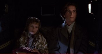 Movie still from “Little Women” (1994), directed by Gillian Armstrong – A man and a woman sitting next to each other on a couch; Medium shot, Low angle