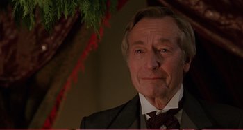 Movie still from “Little Women” (1994), directed by Gillian Armstrong – An older man wearing a suit and tie; Close Up shot, Over the shoulder angle