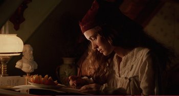 Movie still from “Little Women” (1994), directed by Gillian Armstrong – A young woman wearing a crown writing on a piece of paper; Medium shot, High angle