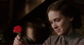 Movie still from “Little Women” (1994), directed by Gillian Armstrong – A woman holding a red rose in her hand; Close Up shot, Over the shoulder angle