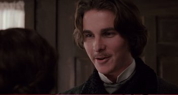 Movie still from “Little Women” (1994), directed by Gillian Armstrong – A man with long brown hair wearing a suit; Close Up shot, Over the shoulder angle