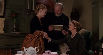 Movie still from “Little Women” (1994), directed by Gillian Armstrong – Two women and an older man are shaking hands; Medium shot, High angle