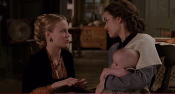 Movie still from “Little Women” (1994), directed by Gillian Armstrong – Two people talking to each other while holding a baby; Medium shot, Over the shoulder angle