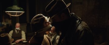 Movie still from “Live by Night” (2016), directed by Ben Affleck – A man and a woman are kissing in the dark; Close Up shot, Over the shoulder angle