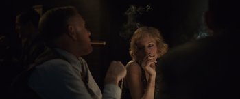 Movie still from “Live by Night” (2016), directed by Ben Affleck – A man and a woman are smoking a cigarette together; Medium shot, Over the shoulder angle