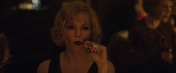 Movie still from “Live by Night” (2016), directed by Ben Affleck – A woman is holding a cigarette in her mouth; Close Up shot, Over the shoulder angle