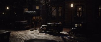 Movie still from “Live by Night” (2016), directed by Ben Affleck – An old car parked on the side of the street; Extreme Wide shot, High angle
