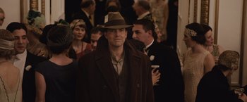 Movie still from “Live by Night” (2016), directed by Ben Affleck – A man wearing a brown hat and a brown coat; Medium shot, Over the shoulder angle