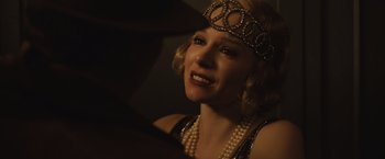 Movie still from “Live by Night” (2016), directed by Ben Affleck – A woman wearing a head piece and pearls; Close Up shot, Over the shoulder angle