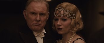 Movie still from “Live by Night” (2016), directed by Ben Affleck – An older man and a young woman wearing pearls; Close Up shot, Low angle