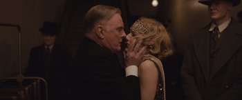 Movie still from “Live by Night” (2016), directed by Ben Affleck – An older man and a young woman are kissing; Close Up shot, Over the shoulder angle