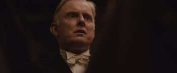 Movie still from “Live by Night” (2016), directed by Ben Affleck – An older man wearing a suit and a bow tie; Close Up shot, Low angle
