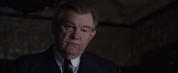 Movie still from “Live by Night” (2016), directed by Ben Affleck – An older man wearing a suit and tie; Close Up shot, Low angle