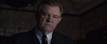 Movie still from “Live by Night” (2016), directed by Ben Affleck – An older man wearing a suit and tie; Close Up shot, Low angle