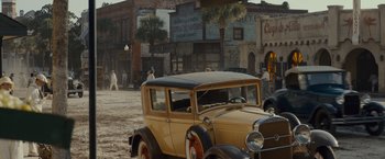 Movie still from “Live by Night” (2016), directed by Ben Affleck – An old car parked on the side of the street; Extreme Wide shot, High angle