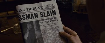 Movie still from “Live by Night” (2016), directed by Ben Affleck – A person holding a newspaper in their hand; Extreme Close Up shot, High angle
