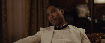 Movie still from “Live by Night” (2016), directed by Ben Affleck – A person wearing a suit and bow tie; Close Up shot, Low angle