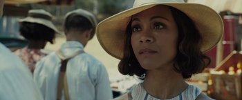 Movie still from “Live by Night” (2016), directed by Ben Affleck – A woman wearing a white hat looking to her left; Close Up shot, Over the shoulder angle