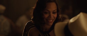 Movie still from “Live by Night” (2016), directed by Ben Affleck – A woman smiles brightly as she looks at a mirror; Close Up shot, Over the shoulder angle