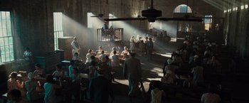Movie still from “Live by Night” (2016), directed by Ben Affleck – A group of people sitting in a room with sun streaming through the windows; Extreme Wide shot, High angle