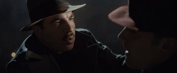 Movie still from “Live by Night” (2016), directed by Ben Affleck – A man with a mustache and a hat talking to another man; Close Up shot, Over the shoulder angle