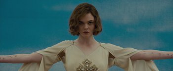 Movie still from “Live by Night” (2016), directed by Ben Affleck – A woman in a white dress is posing for a picture; Close Up shot, Low angle