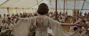 Movie still from “Live by Night” (2016), directed by Ben Affleck – A woman in a white dress standing in front of an audience; Medium shot, Over the shoulder angle