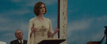 Movie still from “Live by Night” (2016), directed by Ben Affleck – A woman is standing at a lectern with a cross on it; Medium shot, Low angle