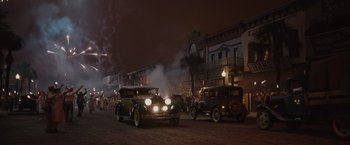 Movie still from “Live by Night” (2016), directed by Ben Affleck – A couple of cars are driving down the street at night; Extreme Wide shot, High angle