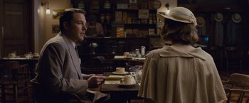 Movie still from “Live by Night” (2016), directed by Ben Affleck – A man and a woman are sitting at a table; Medium shot, Over the shoulder angle