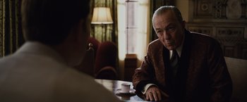 Movie still from “Live by Night” (2016), directed by Ben Affleck – An older man sitting at a table in front of a young man; Medium shot, Over the shoulder angle