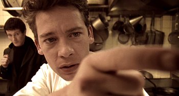 Movie still from “Lock, Stock and Two Smoking Barrels” (1998), directed by Guy Ritchie – A person in a kitchen; Extreme Close Up shot, Low angle