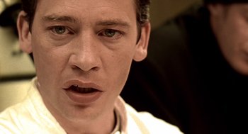 Movie still from “Lock, Stock and Two Smoking Barrels” (1998), directed by Guy Ritchie – A man's face in a white shirt; Extreme Close Up shot, Low angle