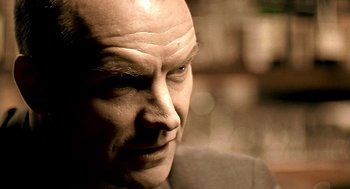 Movie still from “Lock, Stock and Two Smoking Barrels” (1998), directed by Guy Ritchie – A man with a bald head looking to his left; Extreme Close Up shot, Low angle