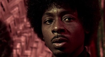 Movie still from “Lock, Stock and Two Smoking Barrels” (1998), directed by Guy Ritchie – A man with a black afro; Close Up shot, Low angle
