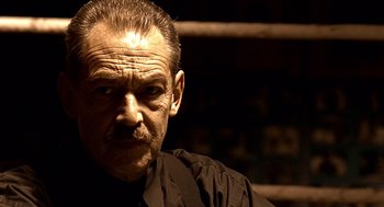 Movie still from “Lock, Stock and Two Smoking Barrels” (1998), directed by Guy Ritchie – An older man with a mustache and a beard; Close Up shot, Low angle